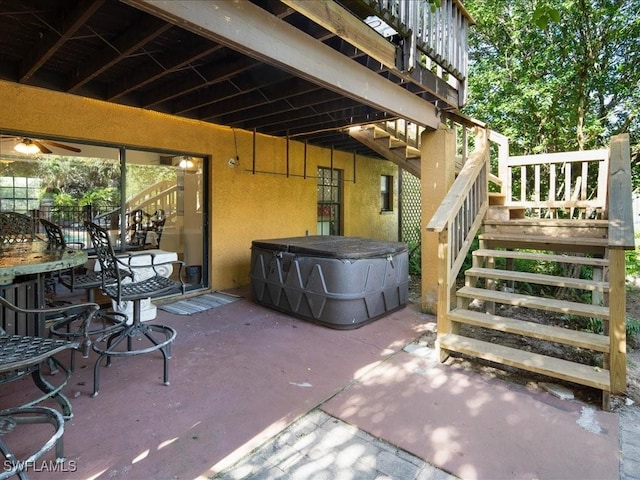 view of patio with stairs and a hot tub