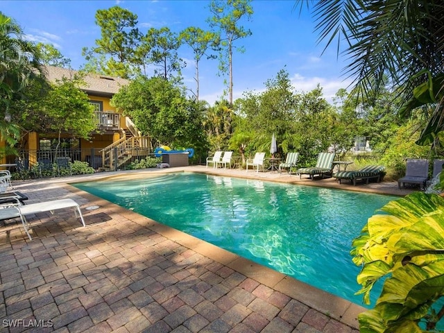 pool featuring a patio area, stairs, and fence