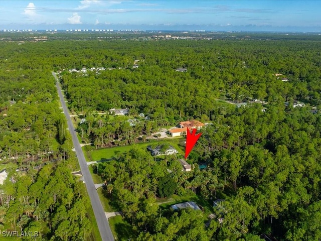 birds eye view of property featuring a view of trees