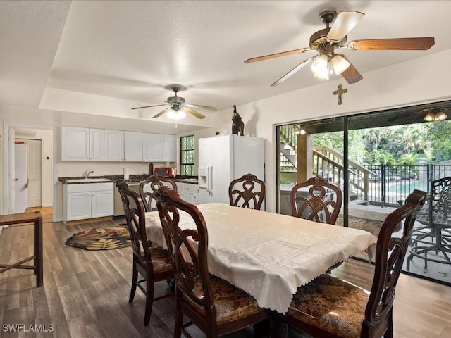 dining space with a ceiling fan and wood finished floors