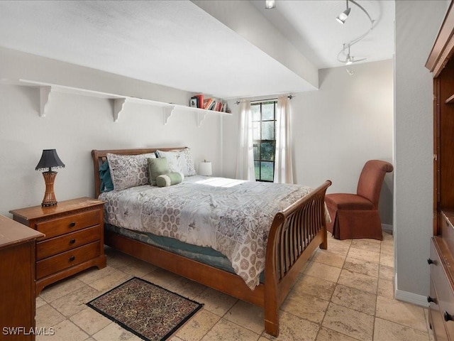 bedroom featuring stone tile flooring and baseboards