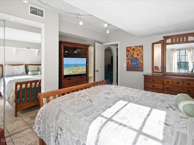 bedroom with arched walkways and visible vents