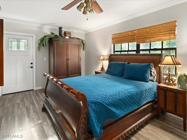 bedroom with baseboards, crown molding, and wood finished floors