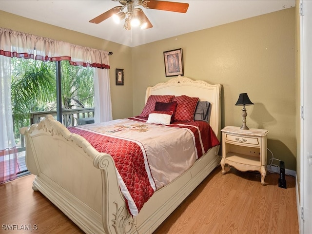 bedroom featuring access to outside, hardwood / wood-style floors, and ceiling fan