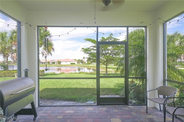 sunroom featuring a water view