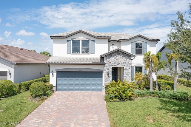 mediterranean / spanish home with a garage and a front lawn