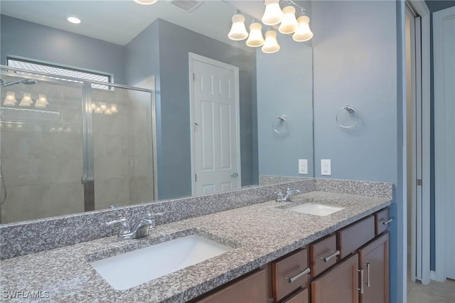 bathroom featuring vanity, an enclosed shower, and a chandelier