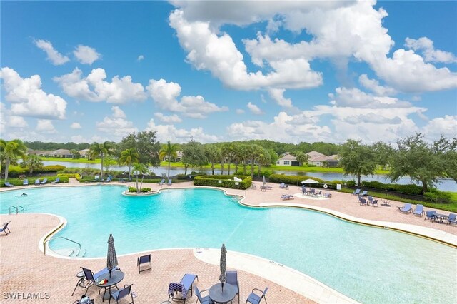 view of swimming pool featuring a water view and a patio area