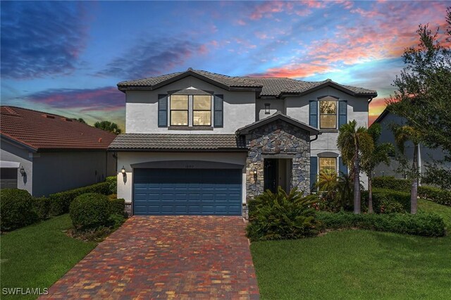 mediterranean / spanish house featuring a garage and a yard