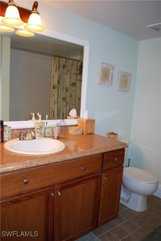 bathroom with toilet, tile patterned floors, and vanity