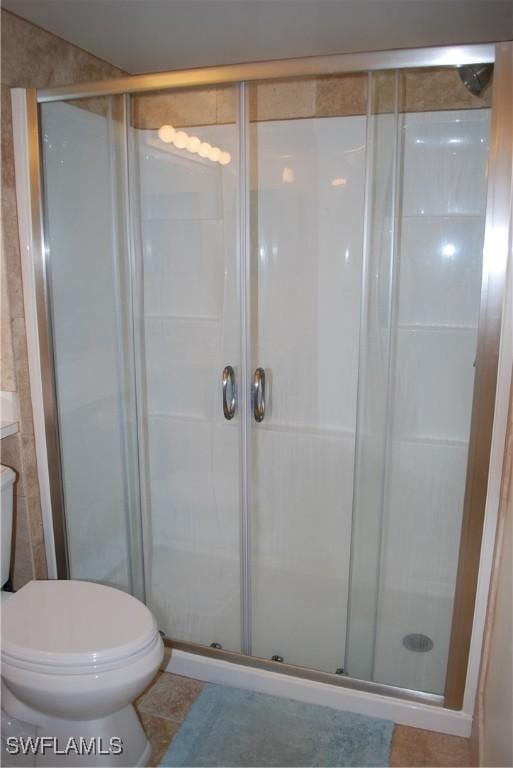 bathroom featuring a shower stall and toilet