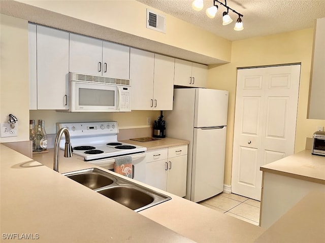 kitchen featuring white appliances, a textured ceiling, light tile patterned flooring, white cabinetry, and track lighting