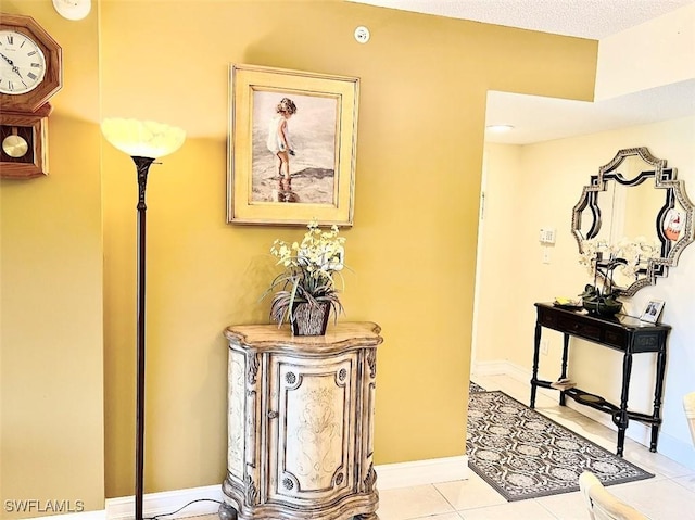 corridor featuring baseboards and light tile patterned floors