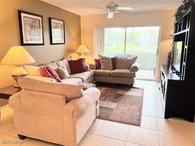 living room featuring light tile patterned floors, a ceiling fan, and a textured ceiling