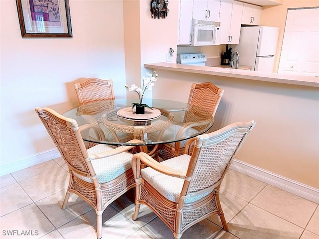 dining room with baseboards and light tile patterned floors