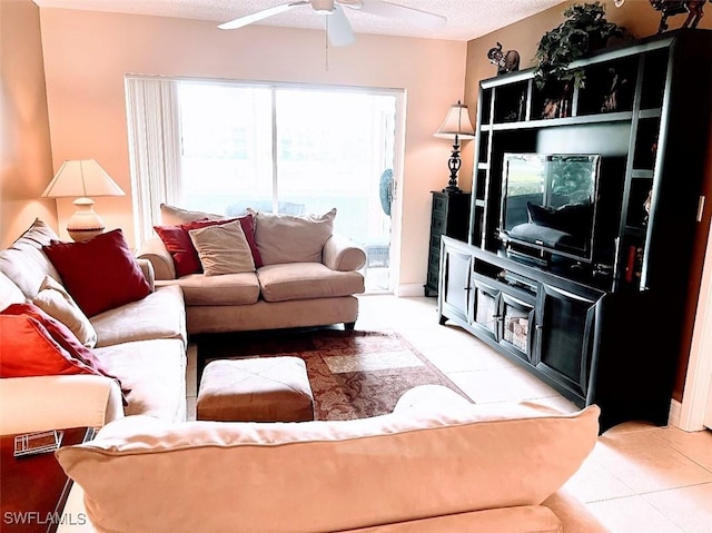 living area featuring light tile patterned floors, ceiling fan, and a textured ceiling