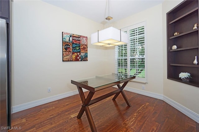 home office with built in shelves and dark hardwood / wood-style floors