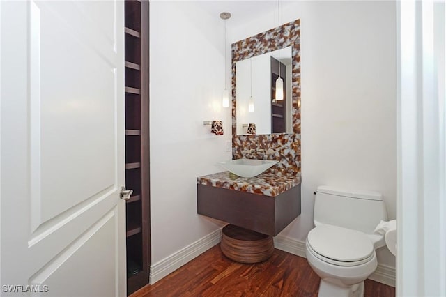 bathroom featuring toilet, hardwood / wood-style floors, and vanity