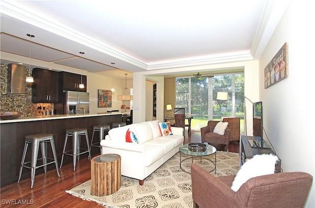 living room featuring ceiling fan, dark hardwood / wood-style floors, a raised ceiling, and crown molding