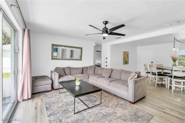 living room with ceiling fan and light wood-type flooring