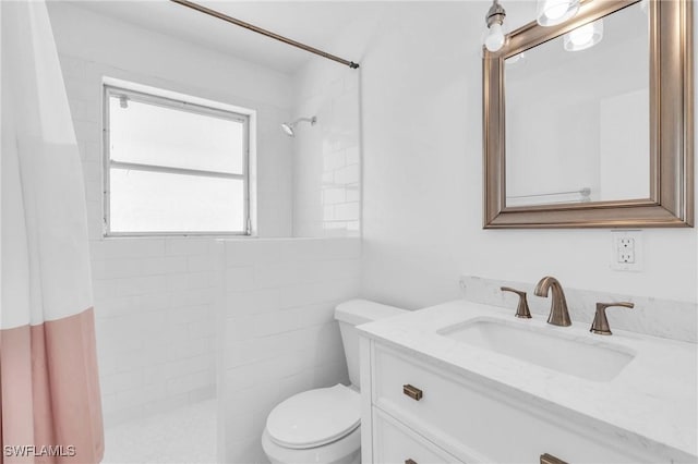 bathroom featuring toilet, vanity, and a shower with shower curtain