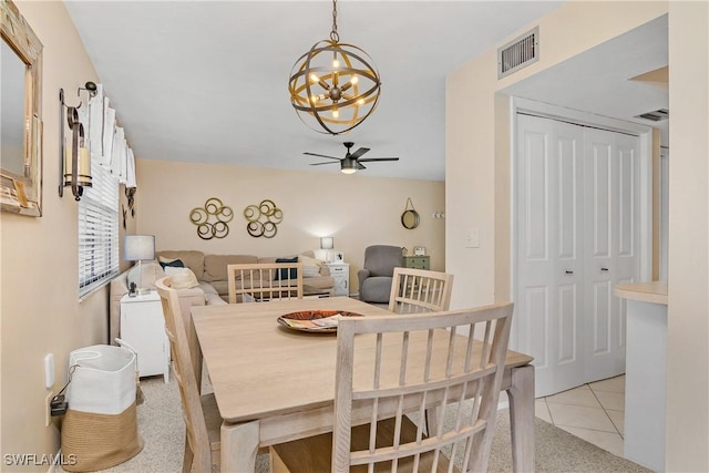 tiled dining area with ceiling fan with notable chandelier