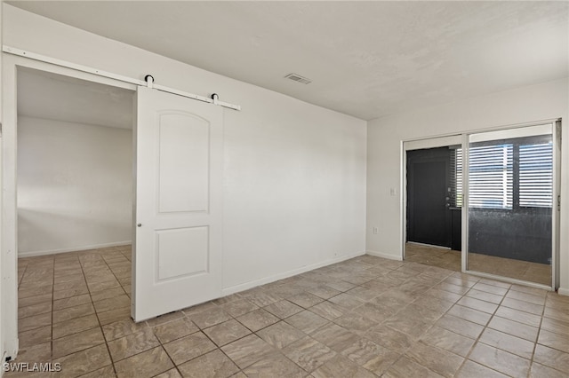 tiled empty room with a barn door