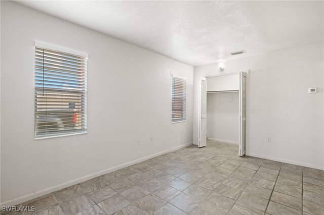 unfurnished bedroom featuring a closet and light tile patterned floors