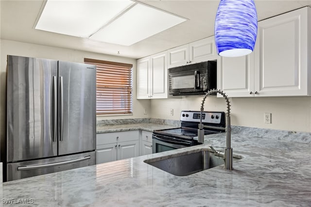 kitchen with appliances with stainless steel finishes, light stone counters, and white cabinetry