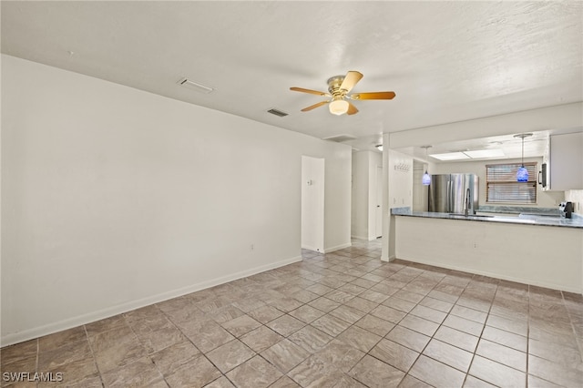 unfurnished living room with light tile patterned floors and ceiling fan