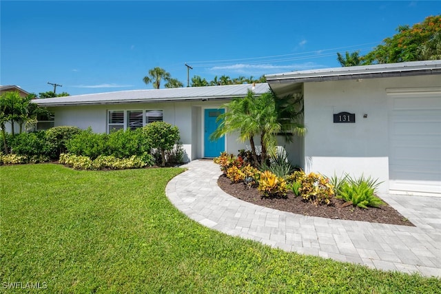 property entrance featuring a garage and a yard