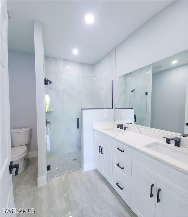 bathroom featuring walk in shower, tile patterned floors, double sink vanity, and toilet