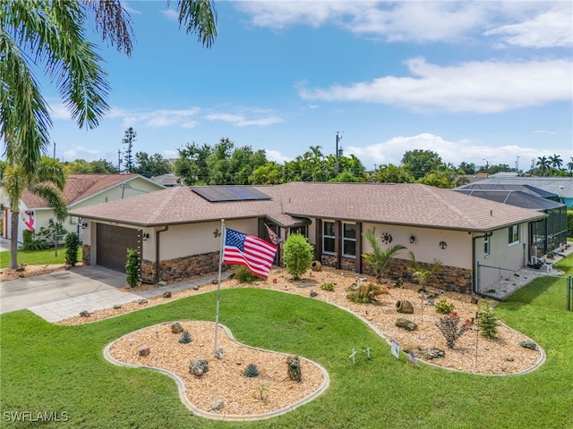 single story home featuring a front yard, solar panels, and a garage