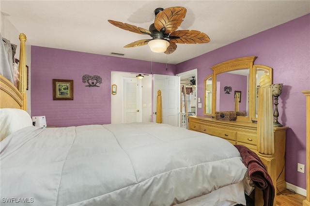 bedroom featuring visible vents, baseboards, ceiling fan, and wood finished floors