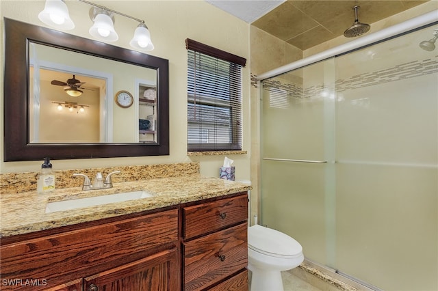 bathroom featuring ceiling fan, toilet, a stall shower, tile patterned floors, and vanity