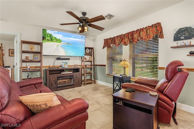 living room with a fireplace, baseboards, visible vents, and ceiling fan