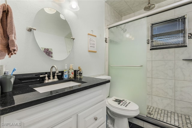 full bath with vanity, toilet, and a stall shower