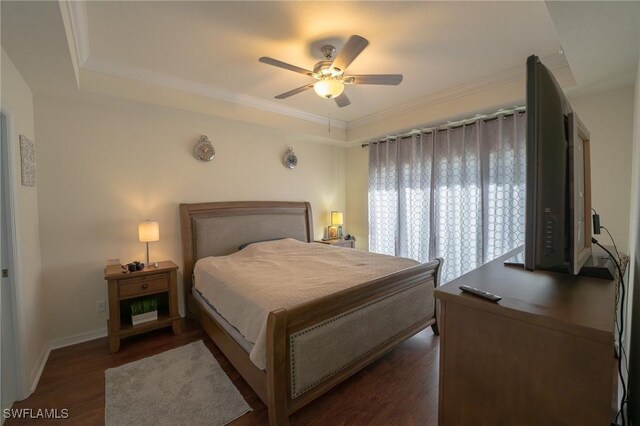 bedroom with ceiling fan, crown molding, dark hardwood / wood-style flooring, and a raised ceiling