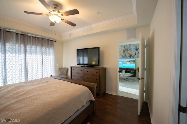 bedroom with ceiling fan, dark wood-type flooring, visible vents, a tray ceiling, and crown molding