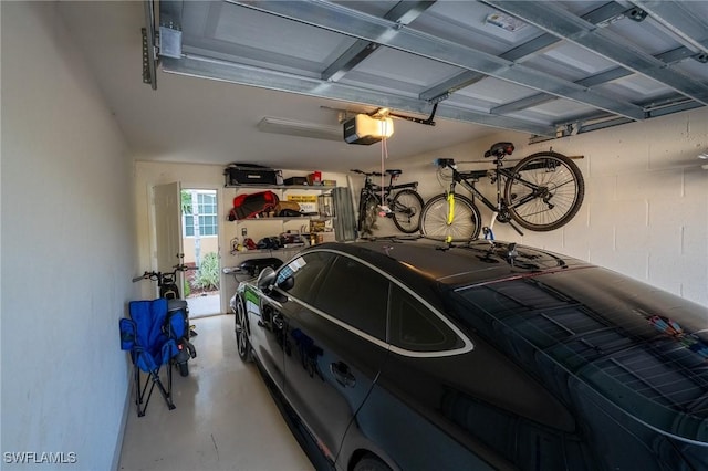 garage featuring a garage door opener and concrete block wall