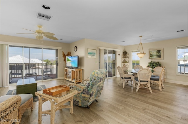 living room featuring light hardwood / wood-style floors and ceiling fan