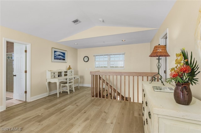 hallway with lofted ceiling and light wood-type flooring