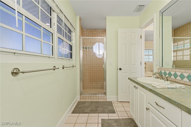 bathroom featuring tile patterned flooring, an enclosed shower, and vanity