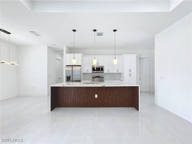 kitchen featuring light tile patterned flooring, appliances with stainless steel finishes, and pendant lighting