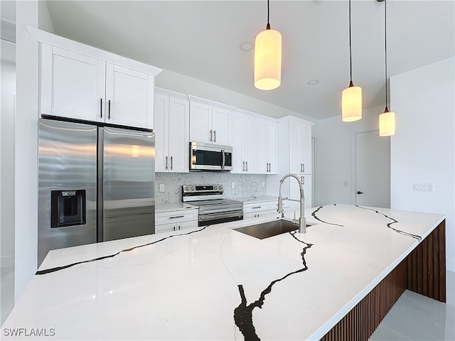 kitchen with backsplash, sink, decorative light fixtures, white cabinetry, and stainless steel appliances