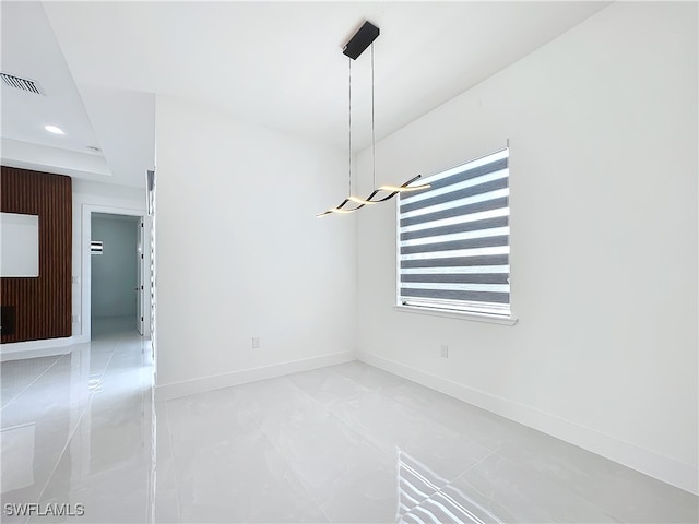 tiled spare room featuring a tray ceiling