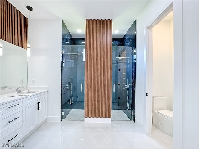 bathroom featuring tile patterned floors, toilet, vanity, and a shower with shower door