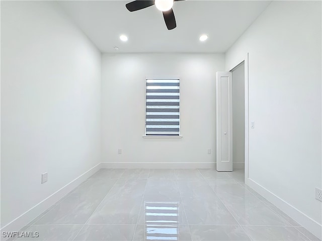 tiled empty room featuring ceiling fan