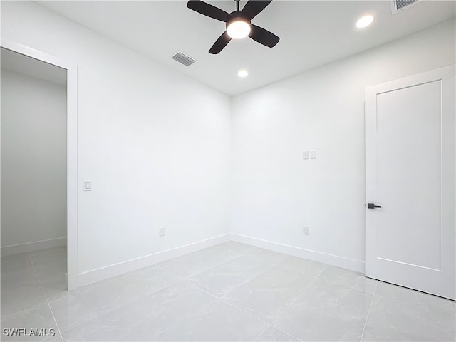 spare room with ceiling fan and light tile patterned floors