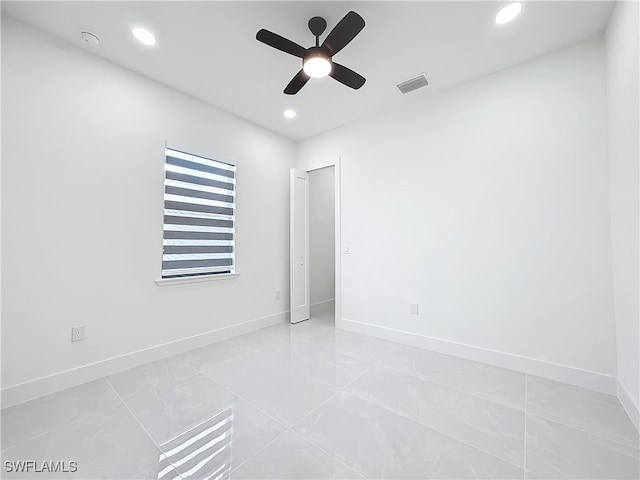 empty room with ceiling fan and tile patterned floors